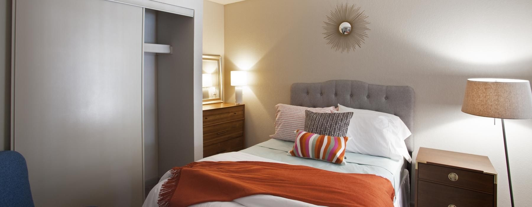 a bed with a orange and white comforter