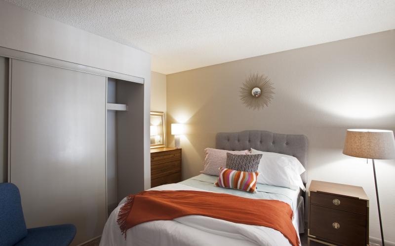 a bed with a orange and white comforter